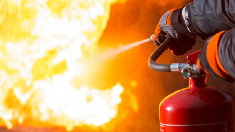 Firefighter pointing the nozzle of a fire extinguisher